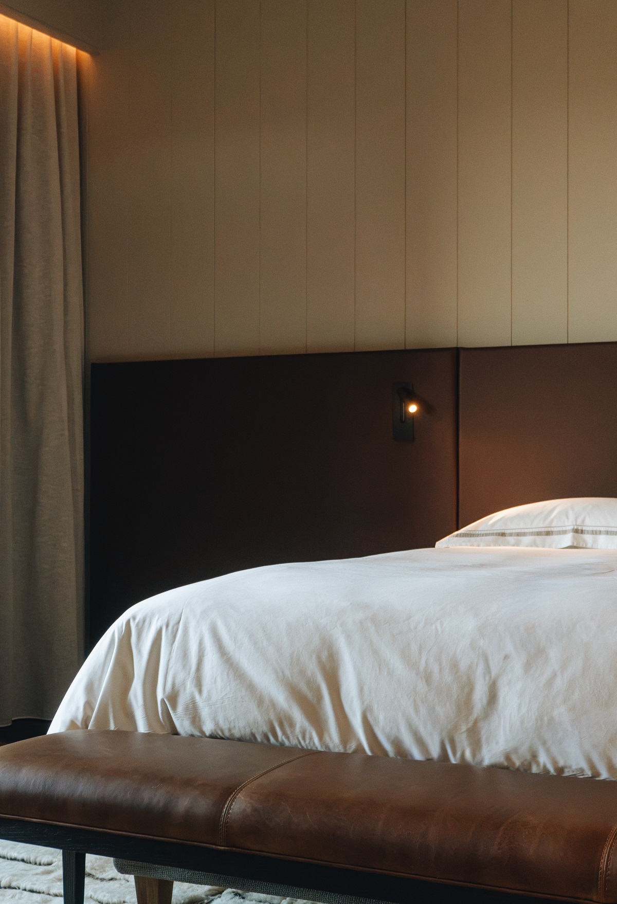 white linen, wood and leather in bedroom 360 Hotel