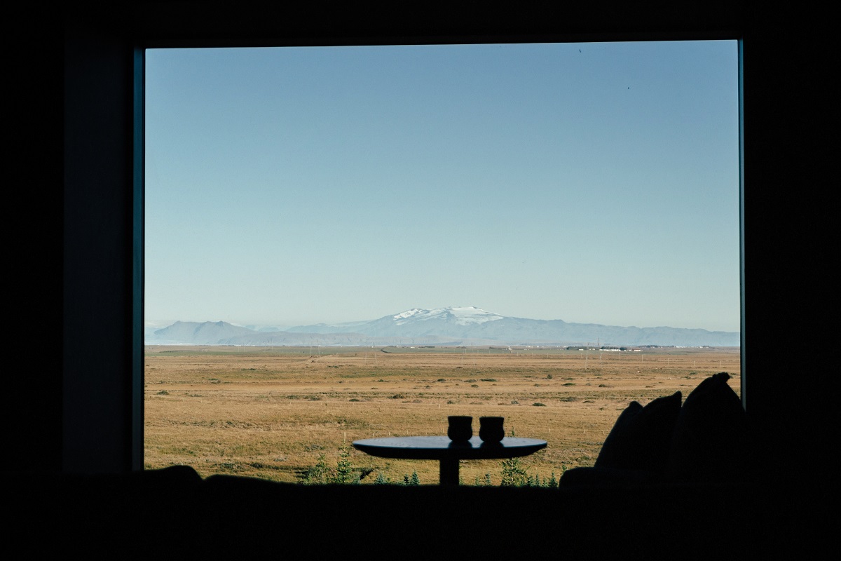 window framing landscape with cushions, tabel and glasses in silhouette