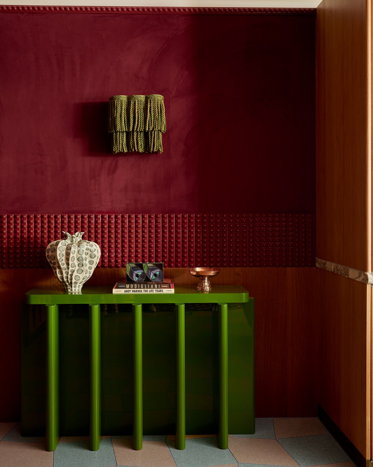 burgundy wall, green shelf with detail