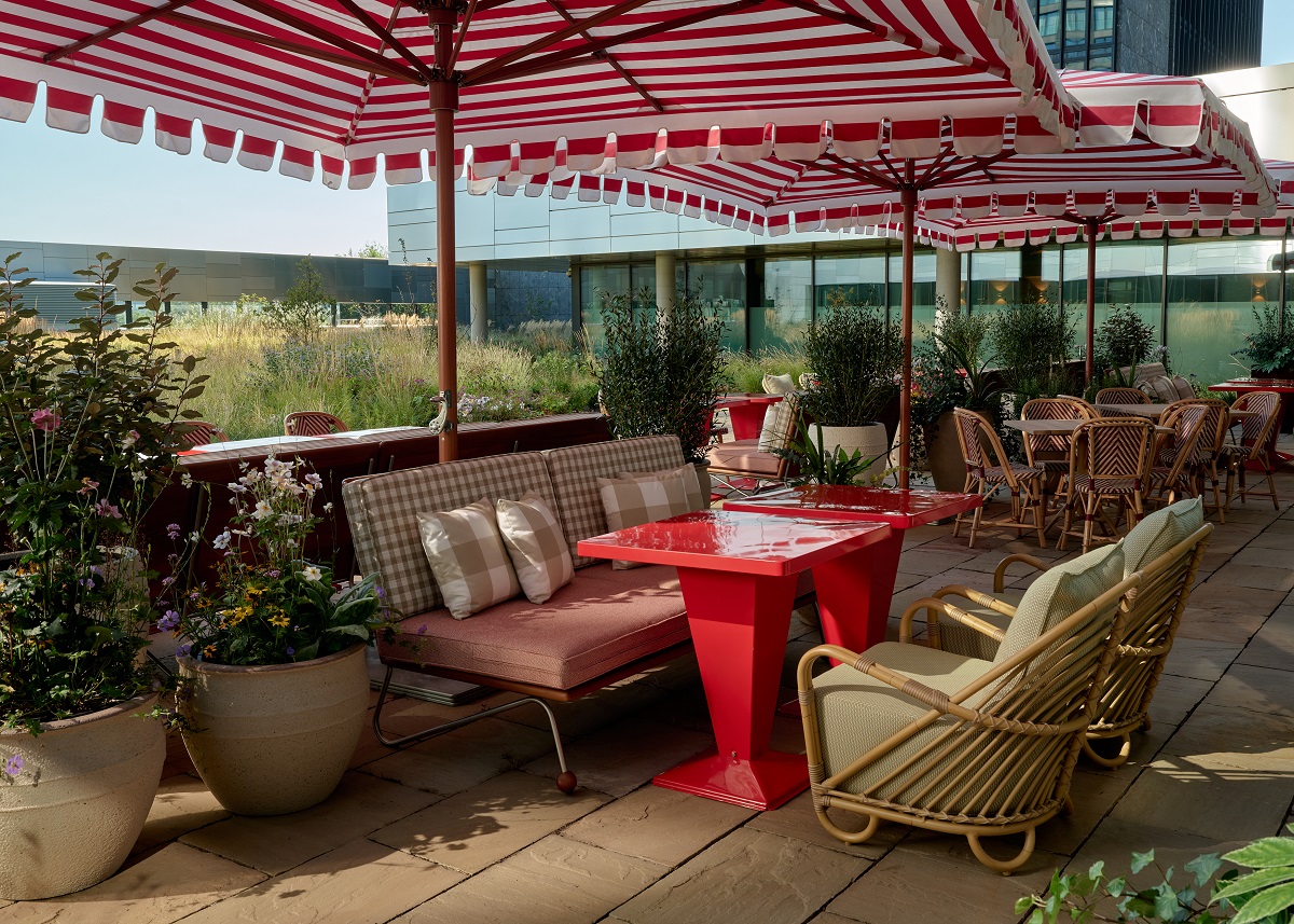 striped umbrellas and wicker chairs on the roof terrace Wilde Amsterdam