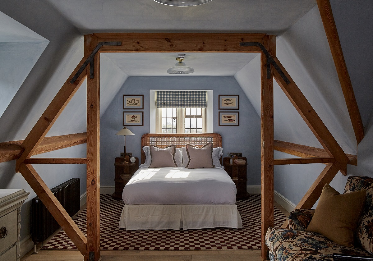 bed in alcove framed by wooden beams with carpet under bed from Pelican House