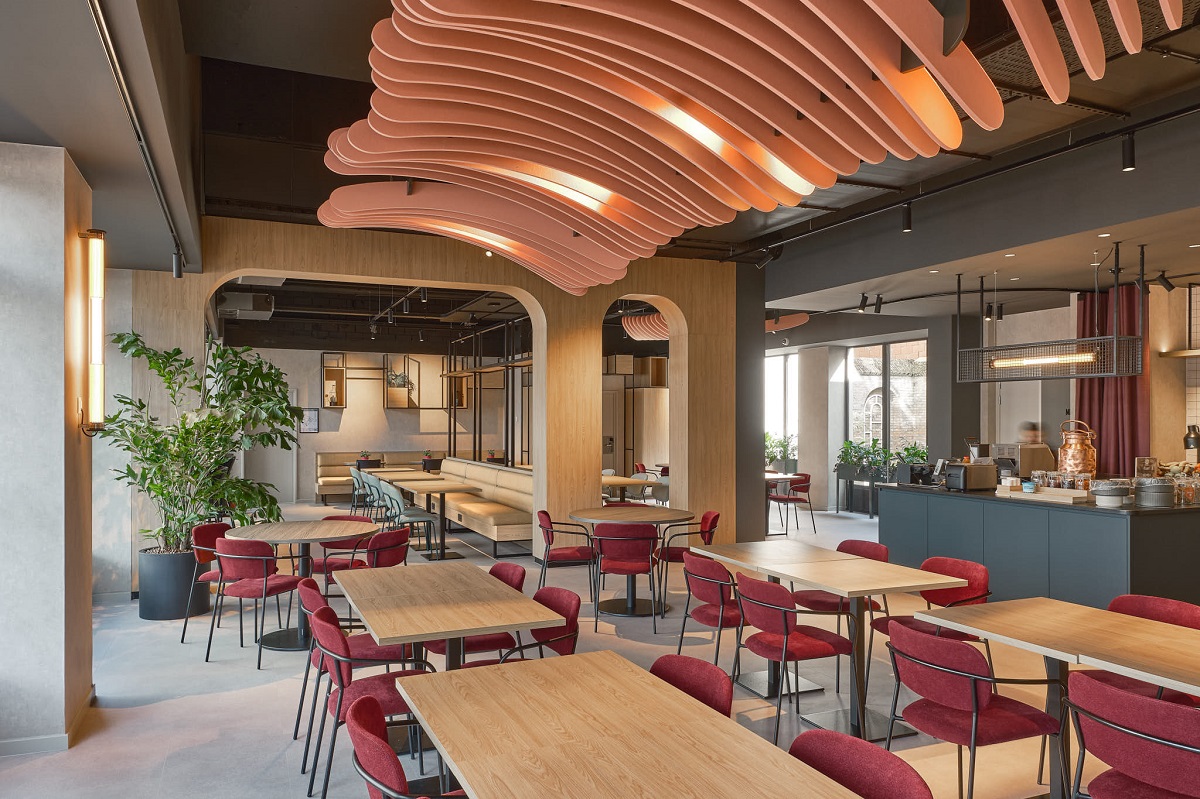 curved ribbed structure in ceiling design by WeWantMore has rethought the lobby of ibis Antwerp Centrum