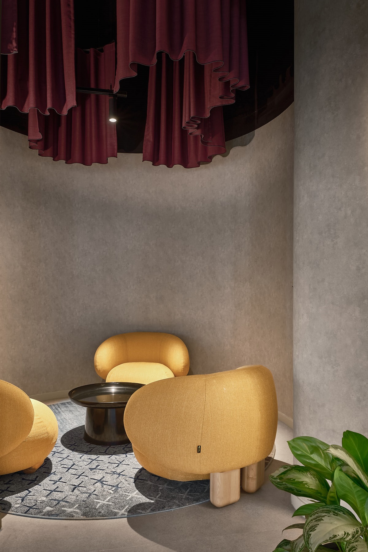 curved yellow seating under draped ceiling