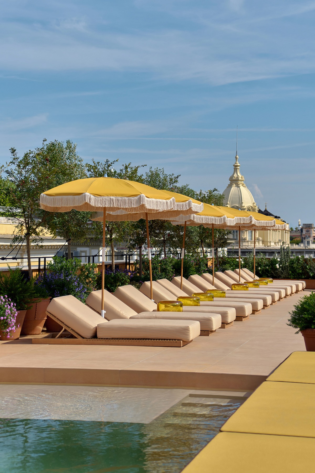 Experimental Roma roof terrace - parasols and sunloungers in yellow stripes next to pool