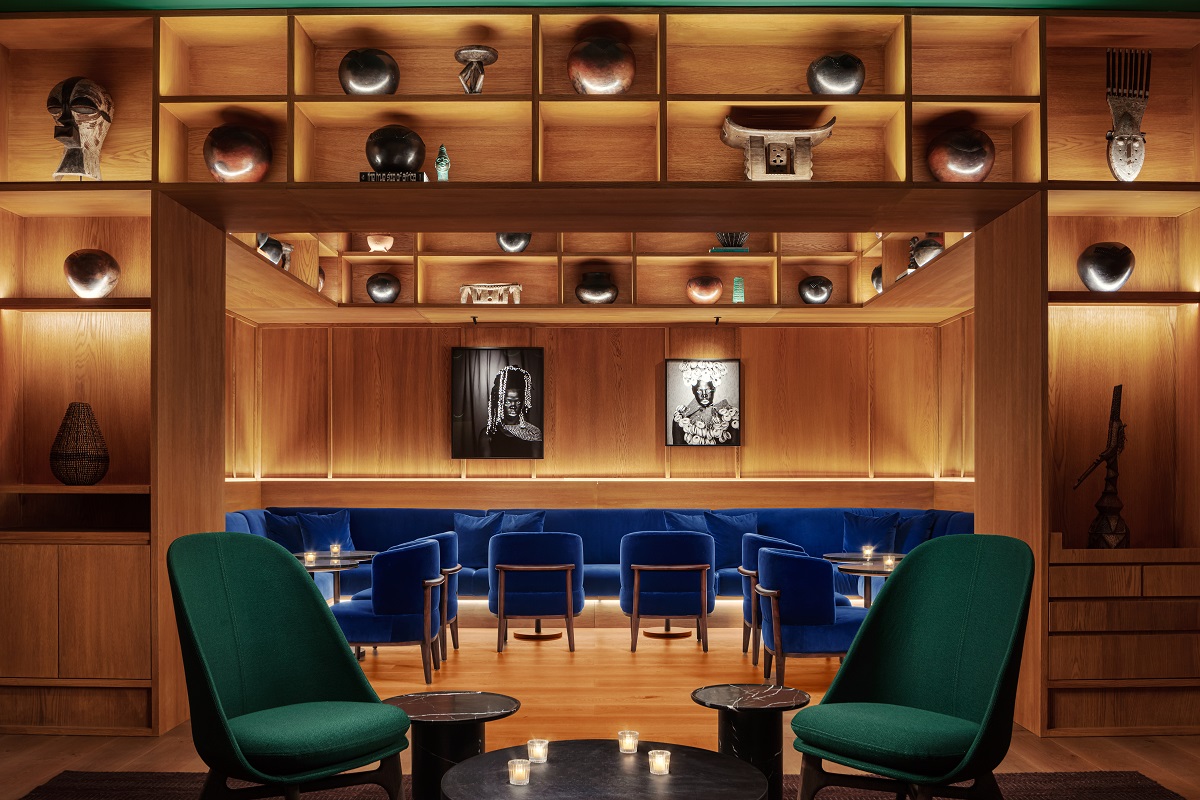cobalt blue couch under black and white portraits in The Cape Town EDITION_Punch Room