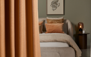 curtain draped in front of bed - Edmund Bell contract blackout fabric