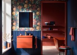 dark orange basin and vanity by Duravit against blue wood panelling and floral wallpaper
