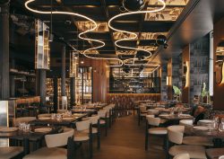 curved statement lighting on ceiling above seating and mirrored surfaces in Astet Roostiq bar and restaurant