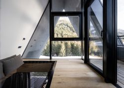 A-frame view onto mountains from loft Olympic Spa Hotel in Val di Fassa designed by NOA