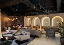 seating and tables in front of backlit arches in Moxy Belfast City - Lounge