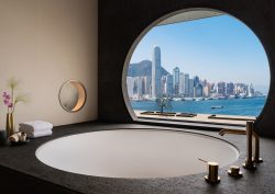 A circular window in hotel bathroom overlooking Hong Kong