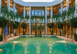 outdoor swimming pool surrounded by rooms and foliage at Aqua Sana Elveden Forest spa