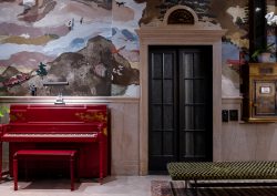 red piano and hand painted wallpaper in the lobby of Asheville Flat Iron Hotel