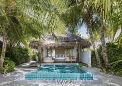palm trees and plunge pool in front of beach cabin at Huvanfen Fushi by BLINK