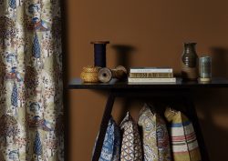 table with books and vases with curtains and cushions in fabric from Edmund Bell