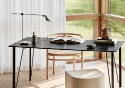 minimalist table as a desk with open book and MS lamp from Fritz Hansen in front of a window
