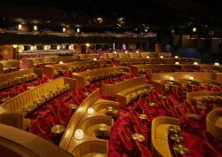 Gold, theatre style seating in a Parisian cabaret hall, with geometric red patterned carpets by Ege Carpets