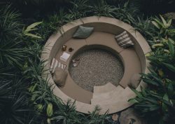 circular outdoor seating pit surrounded by tropical plants at Mantra Hotel in Mexico