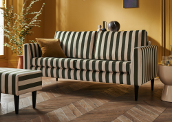 Lounge area with green stripe sofa and footstool with mustard walls, from sofa.com