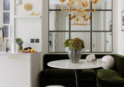 white marble table top with mirrored wall behind and dark seating surround. Liang & Eimil surfaces