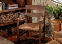 Close up shot of wooden chair and wall mural with bookshelf in Manola Studio designed Hotel Wren