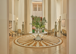 Lobby of The Charles Rocco Forte Hotel, with central table with floral arrangement and intricate circular pattern floor