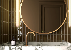 Round mirror by Luma Mirros on green tiled bathroom wall