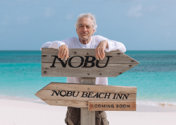 Robert De Niro behind sign for upcoming Nobu Beach Inn