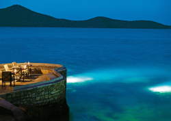 Sumosan restaurant at Elounda Collection, curved stone jetty looks out across ocean at night