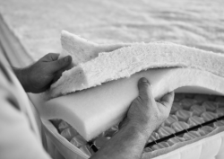 black and white image of layers of mattress fabric being held together by an individual at the Silentnight factory