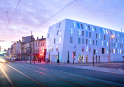 Shot of Seeko'o Hotel in Bordeaux during sunset. Building facade is Corian cladding creating a smooth white outer