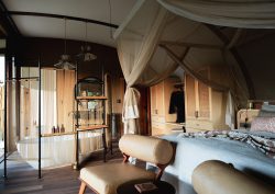 safari lodge bedroom and ensuite with canopy over bed and freestanding bath