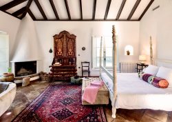 andalucian style interior guestroom with four poster bed and freestanding bath in finca la gloria
