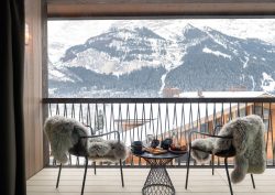 2 chairs with sheepskin throws on hotel balcony with view over snow and mountains