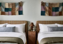 2 beds in Hotel corduroy with decorative textile wallhanging behind