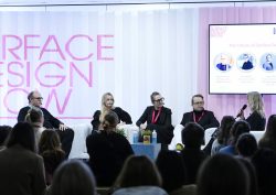 five panellists sit in front of pink and white concertina paper backdrop, on stage at Surface Design Show 2025