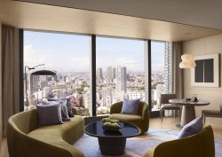curved sofa and seating in front of floor to ceiling window with view over Tokyo
