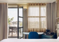 guestroom in Hôtel Dame des Arts with glass door opening onto terrace and views over Paris
