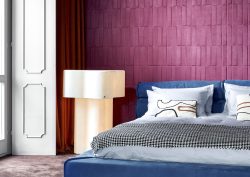 aubergine wall covering from Arte behind bed in grey and blue
