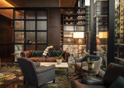 seating and tables in dark interior of Next hotel lobby in Melbourne with reflective surfaces and patterned carpet