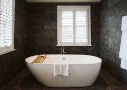 white freestanding bath against slate grey tiles in Petersham Hotel