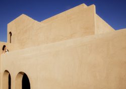 geometric clay facade against blue sky at _Nomade Temple_
