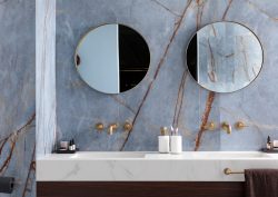 two round mirrors above double vanity in marble bathroom