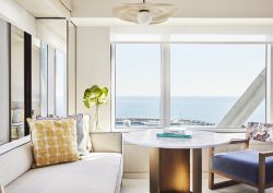 guestroom in Hotel Arts Barcelona with cream couch next to window with sea view