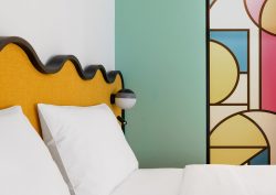 yellow wavy headboard detail and painted mural in guestroom by Studio Shoo in ibis Tiblisi