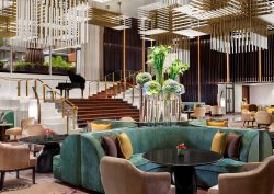 lobby of St Regis Jakarta with statement ceiling lights and plush pink and teal blue seating