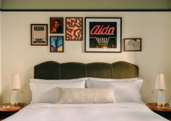 guestroom in The Hoxton Vienna with velvet upholstered headboard and art gallery on the wall