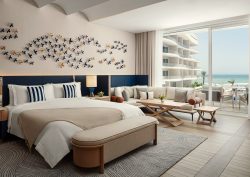 sand coloured throw and blue headboard in guestroom at The St. Regis Al Mouj Muscat Resort