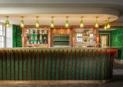 bar counter with green mosaic surface by TREND mosaics and green glass lights above