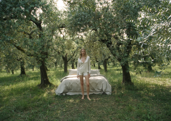 bed made up with Frette bed linen in the middle of olive grove with model in Frette bed wear bed made up with Frette bed linen in the middle of olive grove with model in Frette bed wear